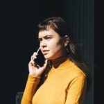 A businessman holding his head in frustration on a phone call representing the Immediate Elevate investment scam warning