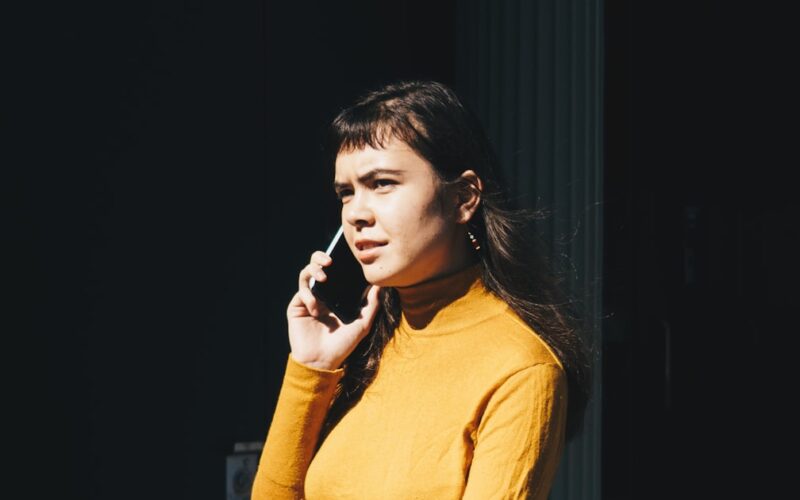 A businessman holding his head in frustration on a phone call representing the Immediate Elevate investment scam warning