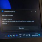 Laptop screen displaying Windows Security protection interface highlighting antivirus software settings